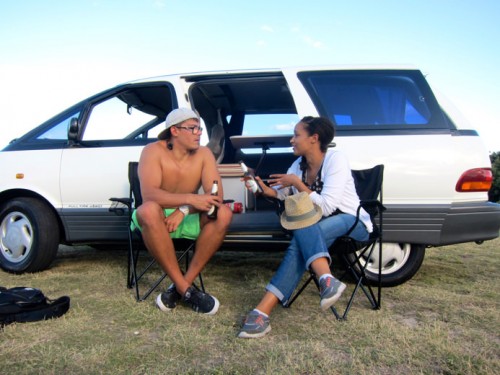 Two travellers emjoying a beer outside of their used campervan for sale