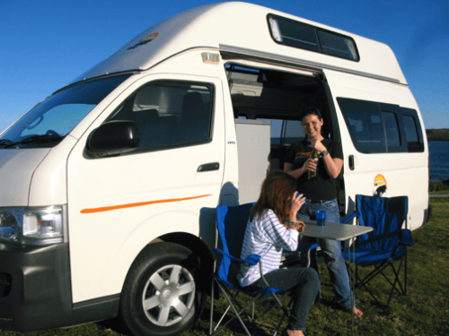 used automatic campervans for sale - two women driving a bottle of wine outside the campervan